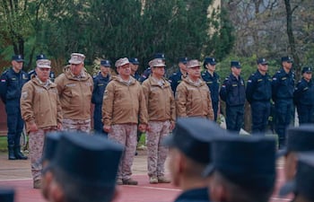 César Roberto Silguero Lobos y otros oficiales militares en uniforme marrón observan a policías alineados durante el evento en Itapúa.