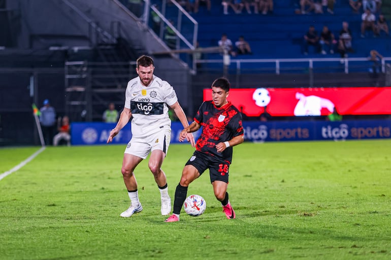 El lateral neozelandés de Olimpia, Tim Payne intenta avanzar por la banda ante la marca del extremo de Sportivo Ameliano, Luis Ortiz.