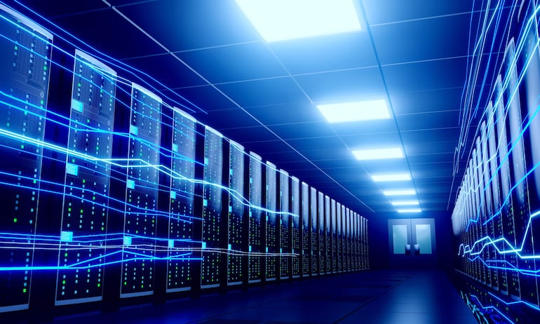 Sala técnica de centro de datos con filas de servidores altos y luces azules y verdes, en un ambiente luminoso y ordenado.