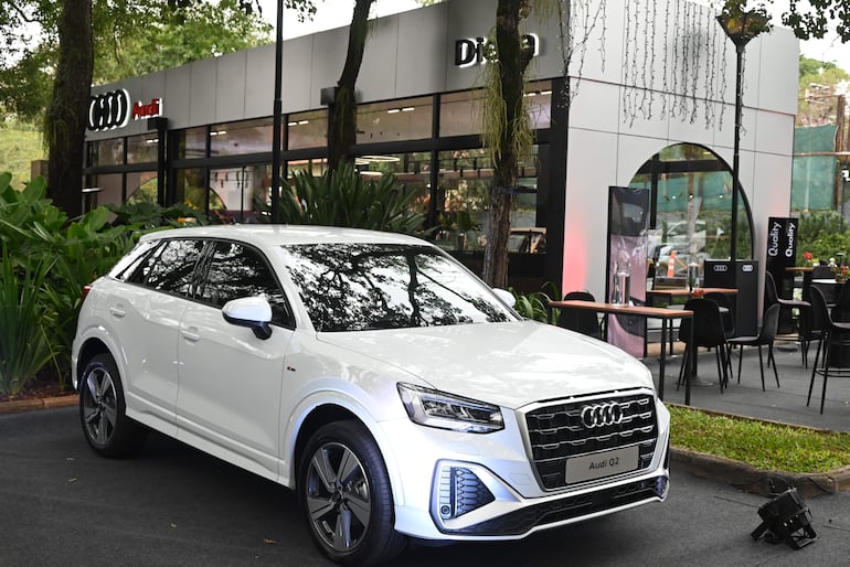 Audi Q2 blanco estacionado en área ajardinada frente al concesionario DIESA, con logotipo de Audi visible detrás.