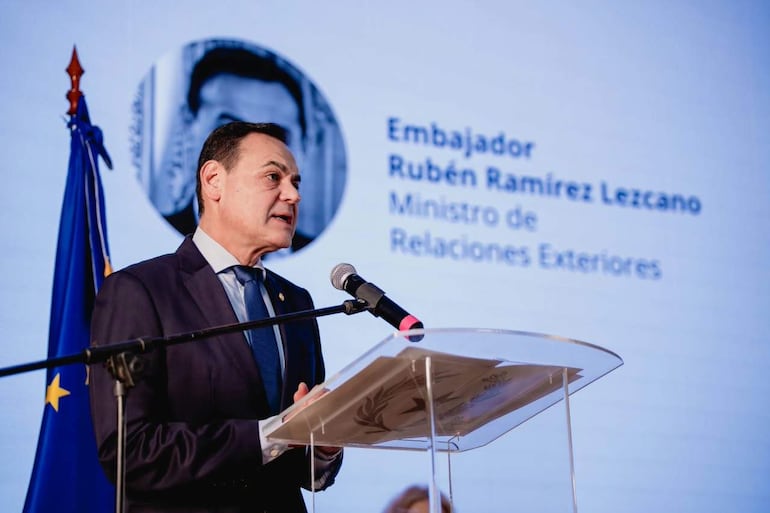 Rubén Ramírez Lezcano en traje oscuro y corbata azul, hablando frente a empresarios, diplomáticos sobre el acuerdo Unión Europea- Mercosur.