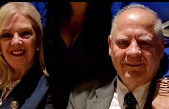 Benítez Riera con saco oscuro y broche, junto a su esposa Sienra Bertón con cabello rubio y saco oscuro, ambos sonrientes en un ambiente informal.