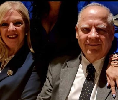 Benítez Riera con saco oscuro y broche, junto a su esposa Sienra Bertón con cabello rubio y saco oscuro, ambos sonrientes en un ambiente informal.