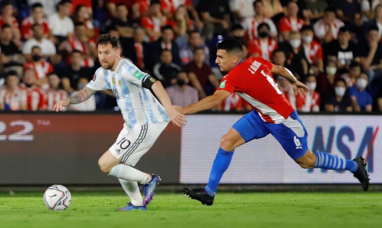 Junior Alonso (d) de Paraguay disputa el balón con Lionel Messi de Argentina, durante un partido por las eliminatorias sudamericanas para el Mundial de Catar 2022, en el estadio Defensores del Chaco en Asunción (Paraguay). 