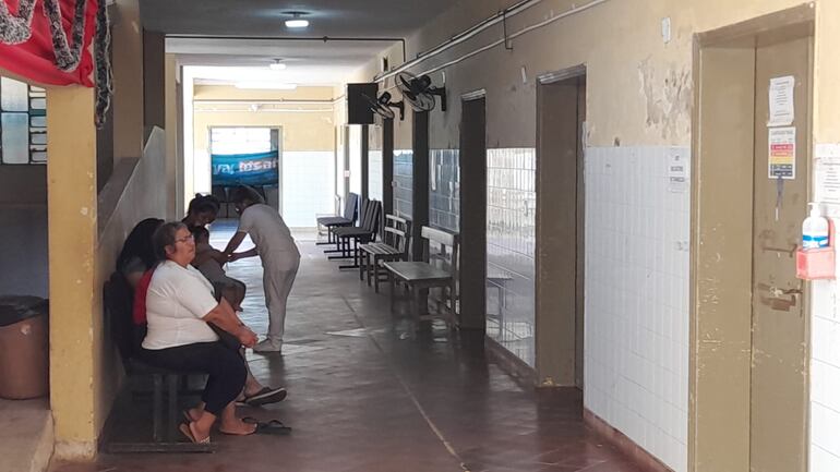 Una enfermera atiende a un paciente en el pasillo del hospital distrital de Alberdi.