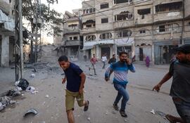 Refugiados palestinos corren ante un ataque del Ejército de Israel.