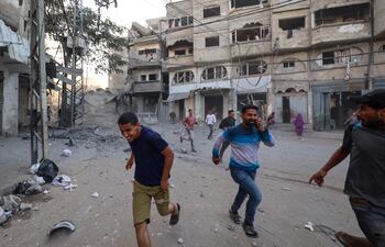 Refugiados palestinos corren ante un ataque del Ejército de Israel.