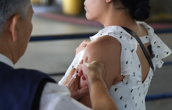 Una mujer se aplica la vacuna contra la influenza.