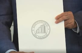 Mano sosteniendo documento del Banco Central del Paraguay, con logotipo impreso en círculo sobre fondo blanco.