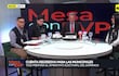 Cuatro personas discuten en un estudio de televisión; presentador canoso sonriente y participantes en chalecos negros observan atentamente.