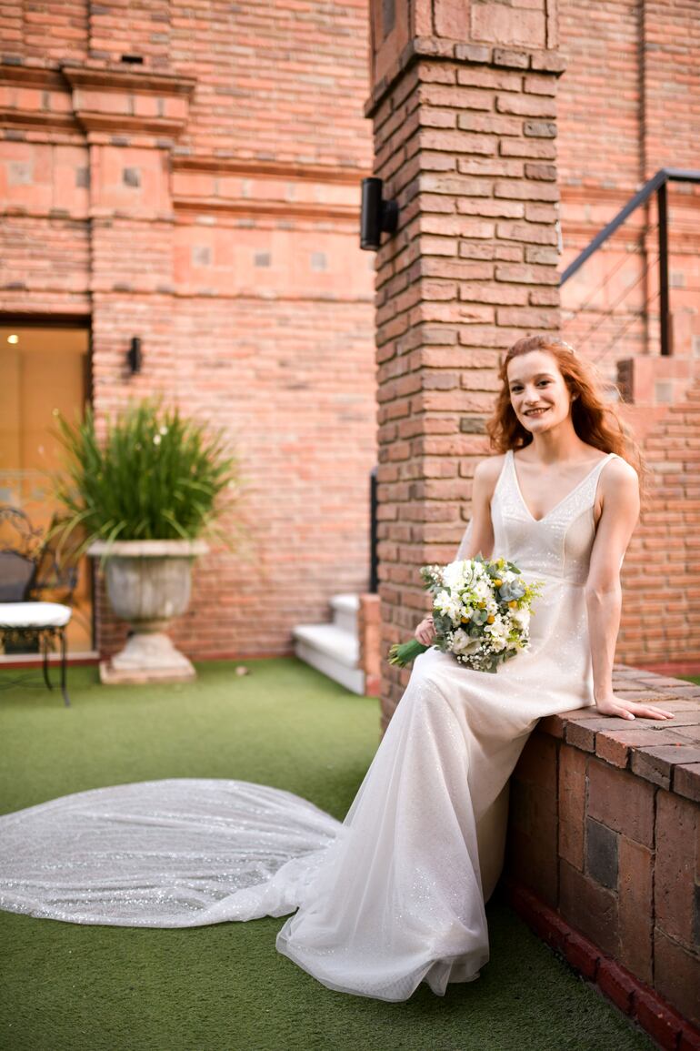 La novia lució un vestido diseñado por Cuyé by Ana González, sobrio y delicado. El tocado fue trabajado con gypshophilas naturales y flores secas amarillas.