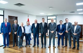 Santiago Peña y ex ministros de Hacienda, todos con trajes formales, alineados en una sala iluminada con una bandera de Paraguay de fondo.