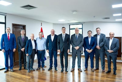 Santiago Peña y ex ministros de Hacienda, todos con trajes formales, alineados en una sala iluminada con una bandera de Paraguay de fondo.