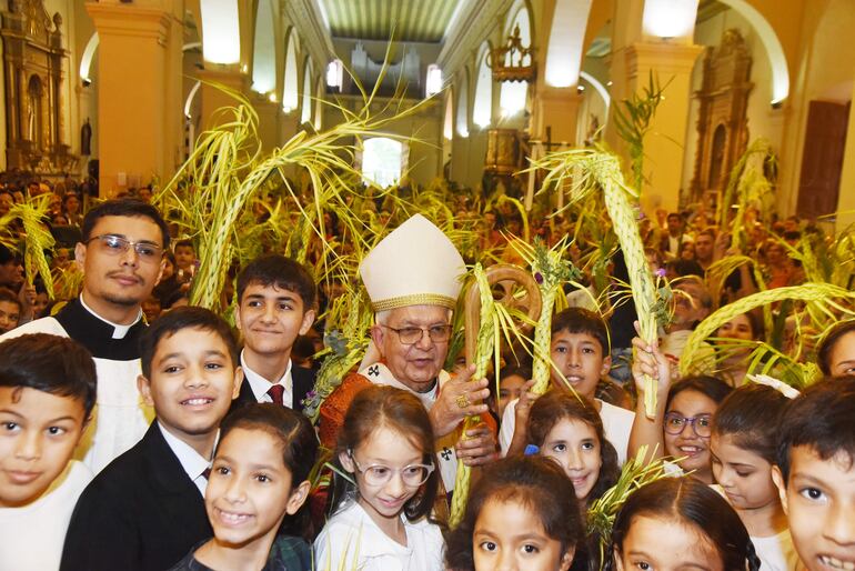 Los niños rodean al cardenal Adalberto Martínez, mientras este realiza la bendición de palmas. 