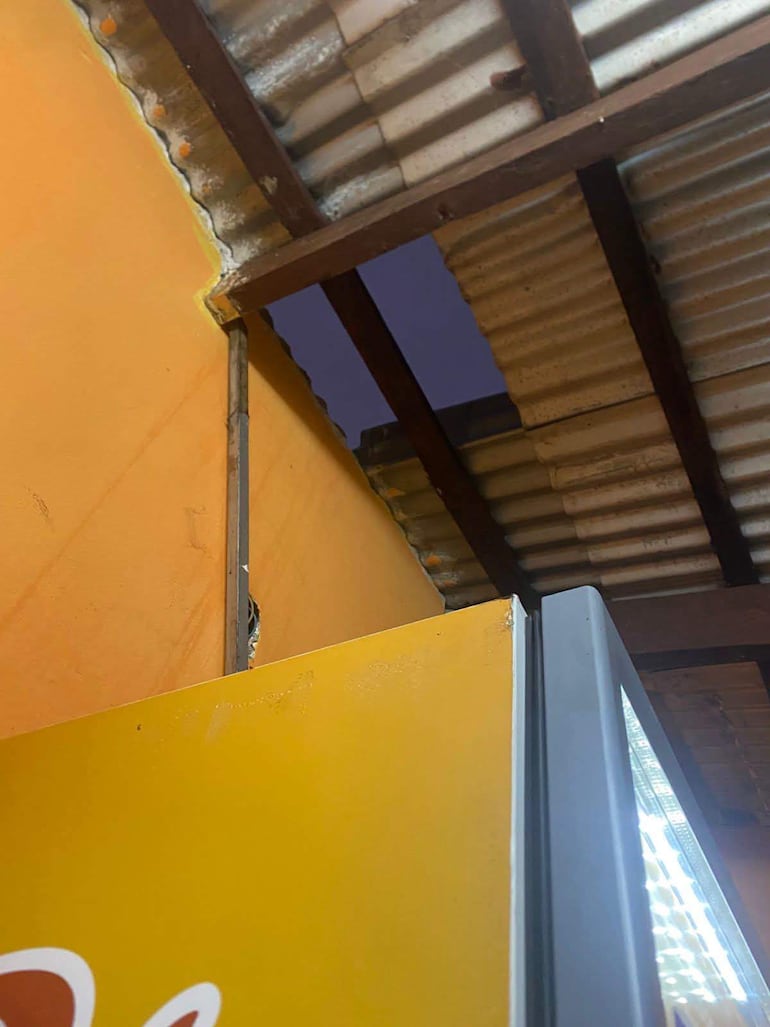 Espacio interior con paredes amarillas, sin personas visibles. Se observa un borde de estructura amarilla, posible cartel o nevera.