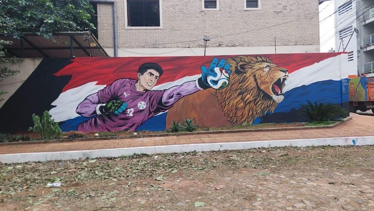 Mural de un portero con camiseta morada y guantes, junto a un león. Fondos con colores de la bandera paraguaya.