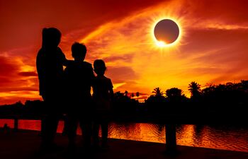 Personas observan un eclipse total de sol.