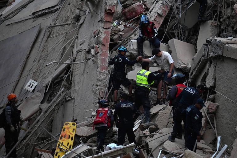 Rescatistas evacuan a una persona de un edificio derrumbado tras un terremoto en Caracas el 24 de junio de 2026. Dos sismos de magnitud 7.2 y 7.5 sacudieron la misma zona de Venezuela la noche del 24 de junio, provocando el derrumbe de edificios, según el Servicio Geológico de Estados Unidos (USGS) y periodistas de AFP.
