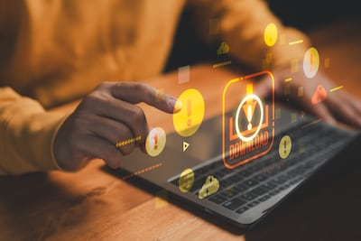 Concepto de advertencia de riesgo de ciberseguridad y Descarga de malware con íconos de alerta en la computadora portátil, que simbolizan amenazas en línea, virus informáticos, archivos inseguros, piratería informática, phishing y seguridad en Internet.