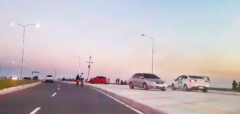 Automovilistas en la vereda de la Costanera Sur.