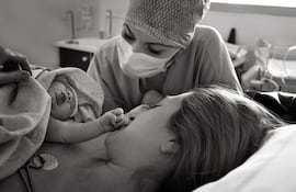 Contacto piel con piel del bebé y la mamá en la sala de partos.