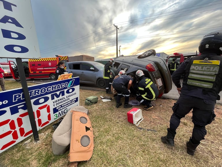 Bomberos y policías intentan socorrer al ocupante de uno de los vehículos accidentados.