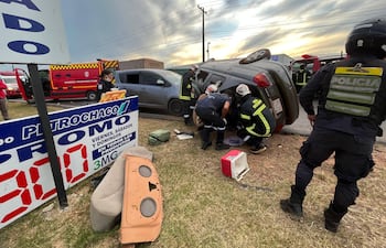 Bomberos y policías intentan socorrer al ocupante de uno de los vehículos accidentados.