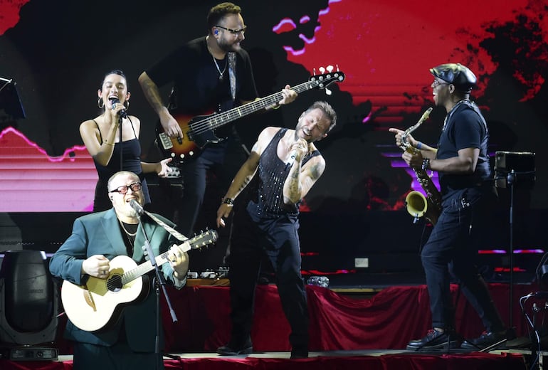 Los integrantes de Sin Bandera en un momento de plena comunión con los artistas que los acompañan en escena.