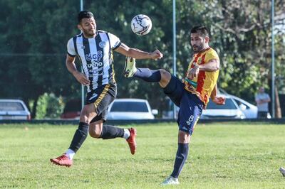 El aurirrojo Jorge Daniel Cáceres eleva la pierna en busca del esférico, ante la presencia del atacante Gilberto González. (Foto: APF)