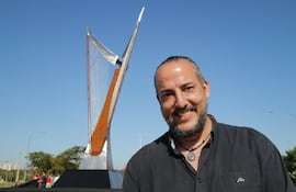 Juan Pablo Pistilli Miranda posa delante de su obra artística en homenaje al arpa paraguaya y al músico y compositor Félix Pérez Cardozo.