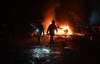 Bomberos ucranianos en el sitio de un ataque ruso en una localidad en las afueras de Járkov, este martes.