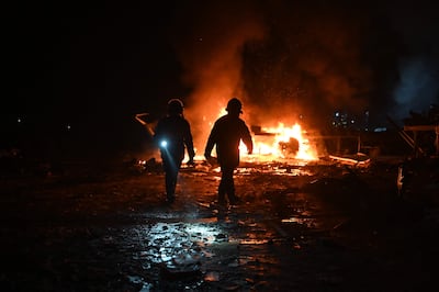 Bomberos ucranianos en el sitio de un ataque ruso en una localidad en las afueras de Járkov, este martes.