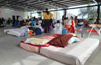 Los familiares de pacientes instalados en el albergue del Hospital Central de IPS llevan sus colchones para pasar la noche en el lugar.