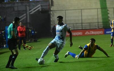 Leandro Meza supera a Rodrigo Alborno ante la atenta mirada de Víctor Bernay en el fondo.