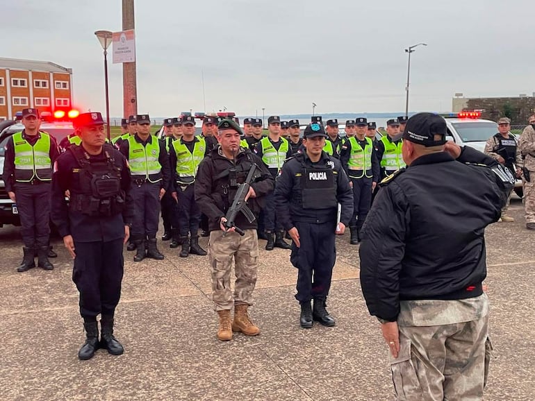 Policías uniformados en formación, con chalecos reflectantes, mientras el comisario general Juan Agüero dirige el evento en ambiente urbano.