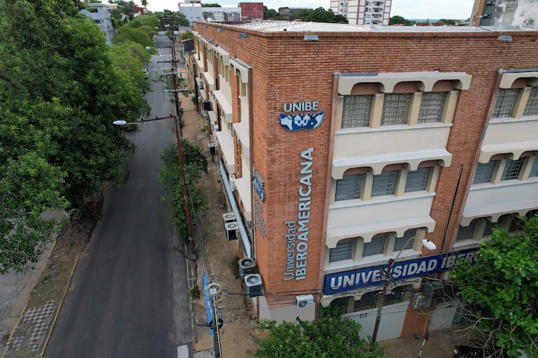Vista aérea del edificio de UNIBE, destacando su fachada de ladrillo y letreros visibles en un entorno urbano.