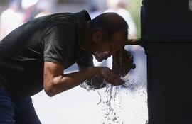 Un hombre se refresca en una fuente, en medio de una ola de calor. (Foto ilustrativa).