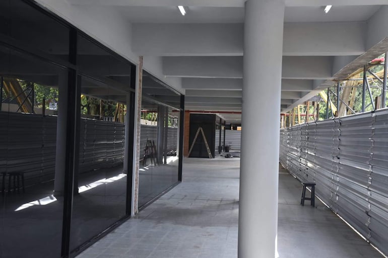 Espacio desocupado en el CTN con paredes claras, columnas y herramientas visibles, reflejando luz en grandes ventanales.