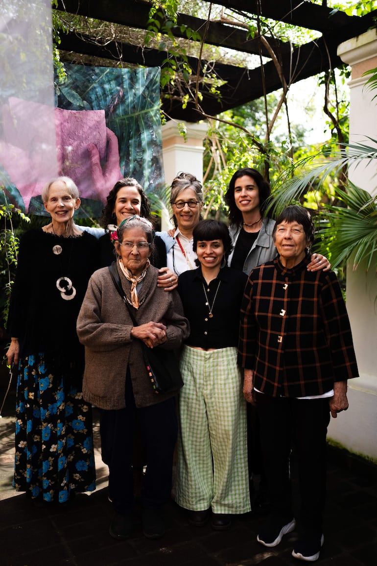 Laura Gorski y Renata Cruz sonriendo junto a otras ceramistas en un entorno verde, posando en un evento artístico al aire libre.