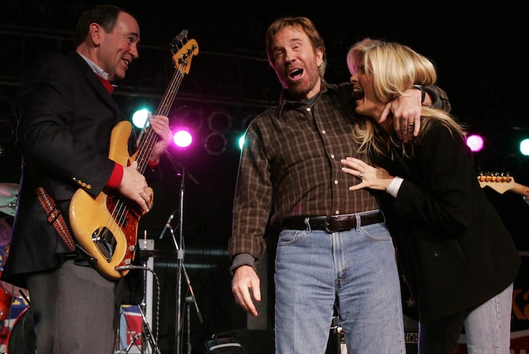 El ex gobernador de Arkansas Mike Huckabee bromea con Chuck Norris y su esposa Gena O'Kelley, durante una fiesta realizada en 2008.