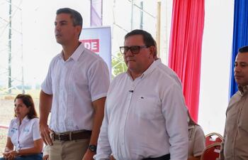 Hernán Rivas con camisa blanca, Santiago Peña Palacios a su lado con gafas.