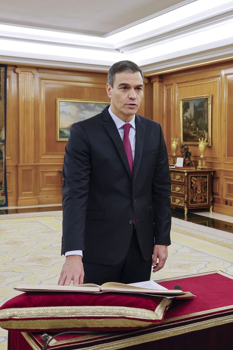 Pedro Sánchez (i) promete su cargo de presidente del Gobierno ante el rey Felipe VI y un ejemplar de la Constitución.