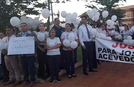 Funcionarios de la Municipalidad de Pedro Juan Caballero y familiares de José Carlos Acevedo, con pancartas y globos blancos durante la manifestación.