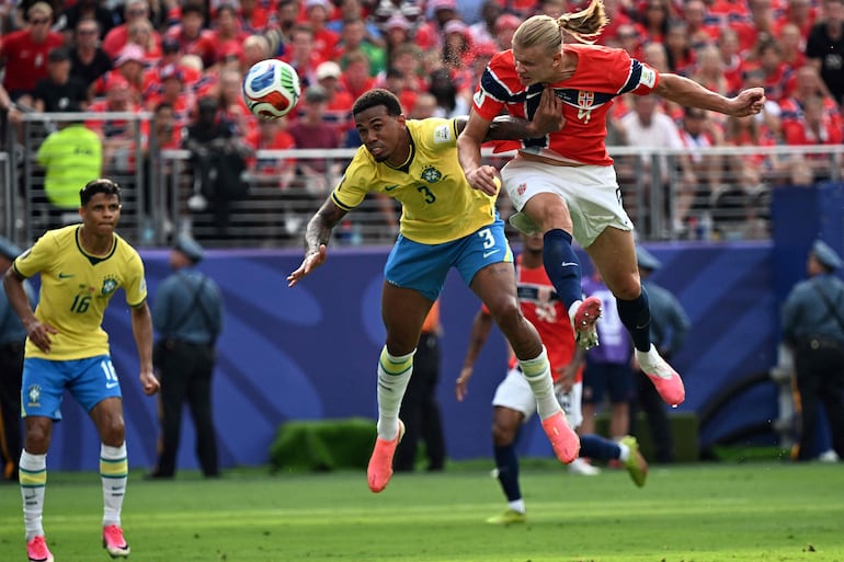 El delantero de Noruega Erling Braut Haaland (D) cabecea el balón y marca el primer gol de su equipo superando al defensor de Brasil #03 Gabriel Magalhaes durante el partido de octavos de final de la Copa Mundial de la FIFA 2026 entre Brasil y Noruega en el New York/New Jersey Stadium en East Rutherford