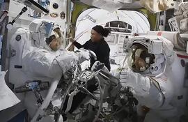 Fotografía cedida por NASA TV de una captura de video donde aparece la astronauta Jeanette Epps (centro) mientras ayuda a sus colegas Mike Barratt (izquierda) y Tracy C. Dyson (derecha) dentro de la esclusa de aire Quest. La caminata espacial de los astronautas de la NASA Tracy C. Dyson y Mike Barrat, prevista para este lunes en la Estación Espacial Internacional (EEI), fue suspendida debido a "una fuga de agua en la unidad de servicio y enfriamiento del traje espacial" de la primera, informó la agencia estadounidense.