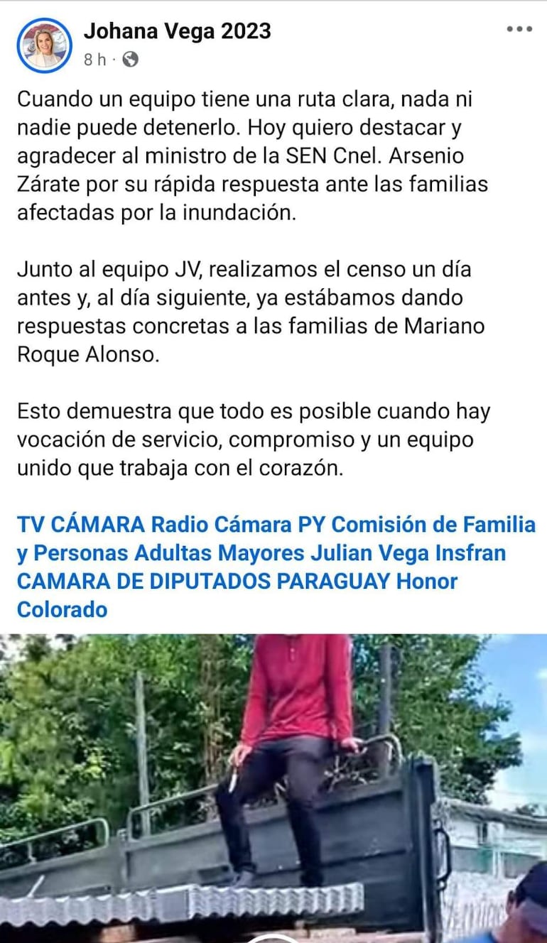 Dos personas en camiseta roja y observador en zona afectada, destacando la ayuda comunitaria ante inundaciones.