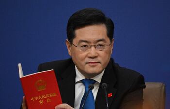 El ministro de Relaciones Exteriores de China, Qin Gang, sostiene una copia de la constitución de China durante una conferencia de prensa en el Centro de Medios del Congreso Nacional del Pueblo (NPC).