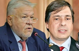 Brítez, con traje oscuro y corbata roja, dialoga con Battaglia, también de traje, en un ambiente formal con micrófonos.