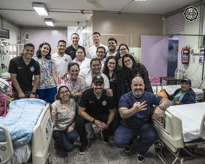 Los representantes de Olimpia durante su visita al Hospital de Clínicas, en compañía de los familiares de los pacientes y los funcionarios del sanatorio.