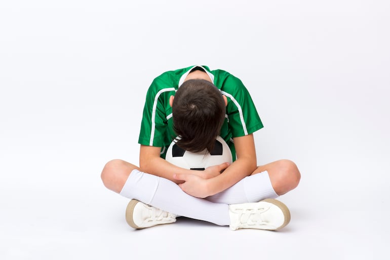 Niño triste tras la derrota en un juego deportivo, imagen ilustrativa.